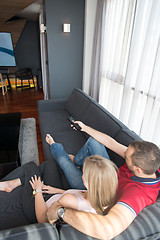 Image showing Young couple on the sofa watching television