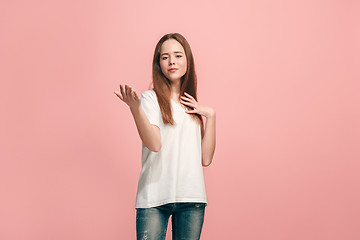 Image showing The happy teen girl standing and smiling against pink background.