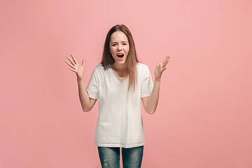 Image showing Portrait of angry teen girl on a pink studio background