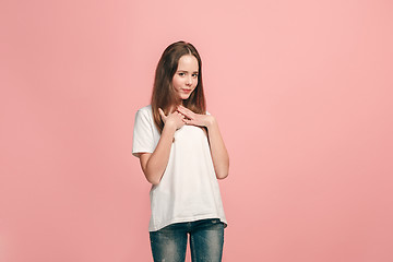 Image showing The happy teen girl standing and smiling against pink background.