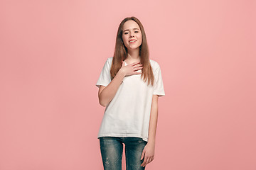 Image showing The happy teen girl standing and smiling against pink background.