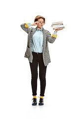 Image showing Full length portrait of a sad female student holding books isolated on white background