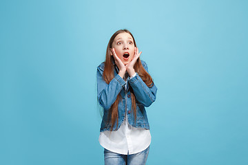 Image showing Beautiful teen girl looking suprised isolated on blue