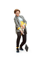 Image showing Full length portrait of a unhappy female student holding books isolated on white background