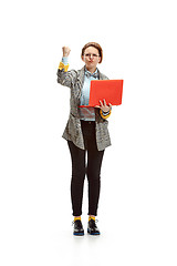 Image showing Full length portrait of a angry female student holding notebook isolated on white background