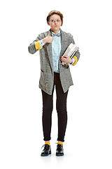 Image showing Full length portrait of a surprised female student holding books isolated on white background