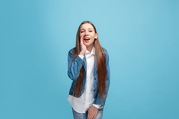 Image showing Isolated on pink young casual teen girl shouting at studio