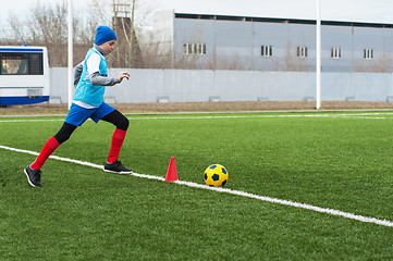 Image showing Boy kicking soccer ball