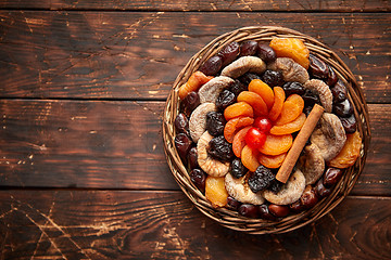 Image showing Mix of dried fruits in a small wicker basket on wooden table