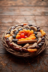 Image showing Mix of dried fruits in a small wicker basket on wooden table