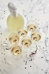 Image showing Champagne glasses and bottle placed on white marble background