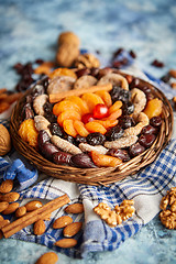 Image showing Composition of dried fruits and nuts in small wicker bowl placed on stone table