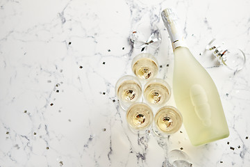 Image showing Champagne glasses and bottle placed on white marble background