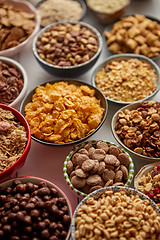 Image showing Assortment of different kinds cereals placed in ceramic bowls on table