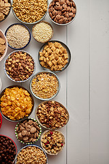 Image showing Assortment of different kinds cereals placed in ceramic bowls on table