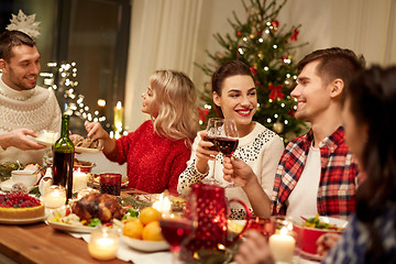 Image showing happy friends having christmas dinner at home