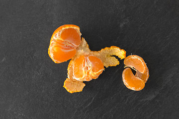 Image showing close up of peeled mandarin on slate table top