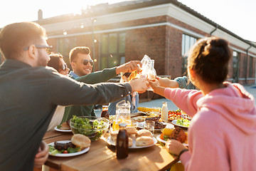 Image showing happy friends toasting drinks at rooftop party