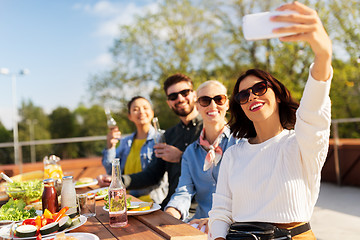 Image showing happy friends taking selfie at rooftop party