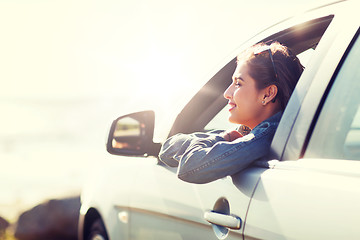 Image showing happy teenage girl or young woman in car