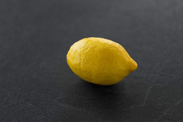 Image showing close up of whole lemon on slate table top