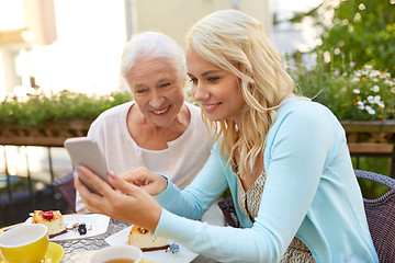 Image showing daughter and senior mother with smartphone at cafe