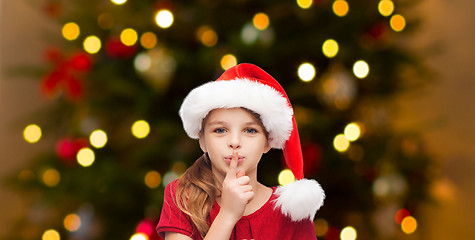 Image showing girl in santa hat over christmas tree lights