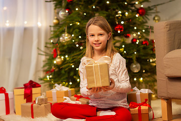 Image showing smiling girl with christmas gift at home