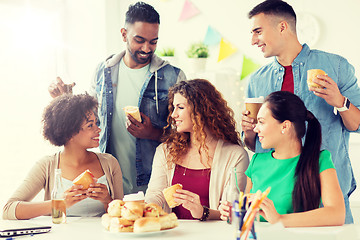 Image showing happy friends or team eating at office party