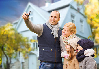 Image showing family takes autumn selfie by cellphone over house