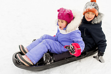 Image showing little kids sliding on sled down hill in winter