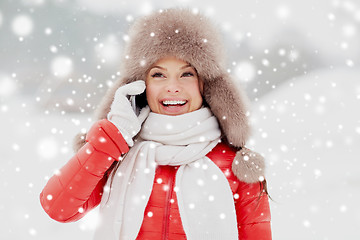 Image showing happy woman in winter hat calling on smartphone