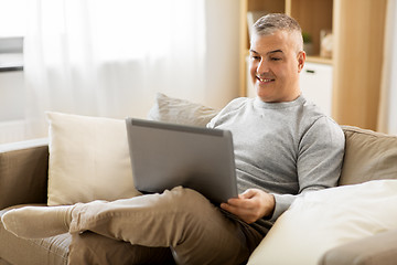 Image showing man with laptop computer sitting on sofa at home