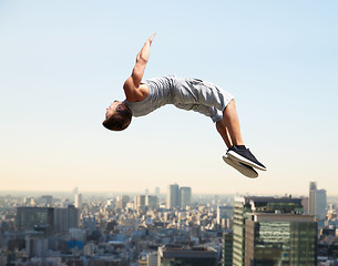 Image showing man making parkour jumping over tokyo city