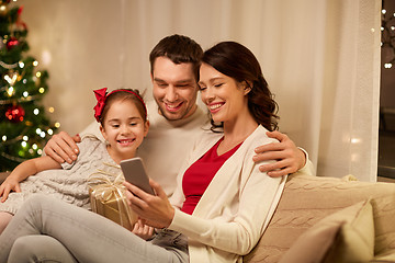 Image showing family with smartphone at home on christmas