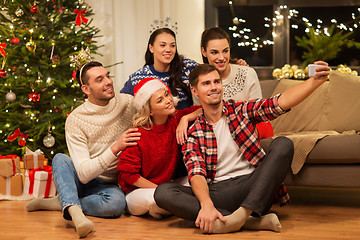 Image showing friends celebrating christmas and taking selfie