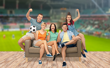 Image showing friends or football fans with soccer ball on sofa