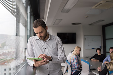 Image showing Businessman Using Tablet In Office Building by window