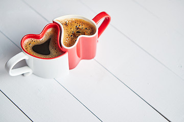 Image showing Two heart shaped coffee cups conected with each other.