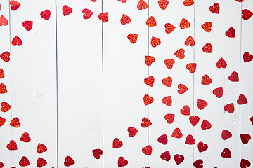 Image showing Vlentine\'s Day composition. Heart shaped sequins placed on white wooden table