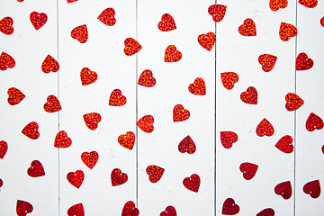 Image showing Vlentine\'s Day composition. Heart shaped sequins placed on white wooden table