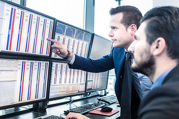 Image showing Stock traders looking at market data on computer screens.