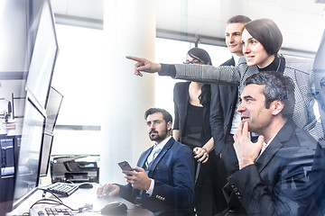 Image showing Successful business team looking at trade data on computer screens in corporate office.