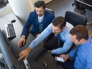 Image showing Business team analyzing trade data on computer in corporate trading office.