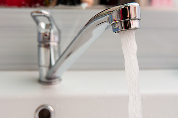 Image showing Water pours more pressure from the mixer in the bathroom