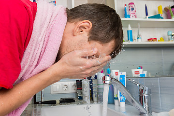 Image showing Man washing his face in the morning in the bathroom