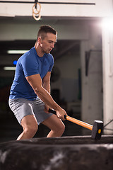 Image showing man workout with hammer and tractor tire