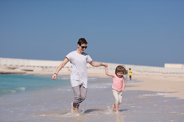 Image showing mother and daughter running on the beach