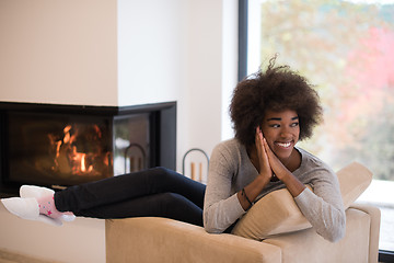 Image showing black woman in front of fireplace