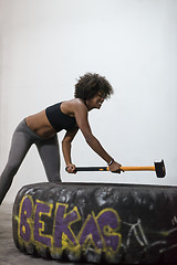 Image showing black woman workout with hammer and tractor tire